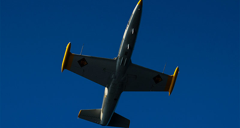 L-39 Albatros jet soaring high against the blue sky with NovAtel’s products strapped inside. 